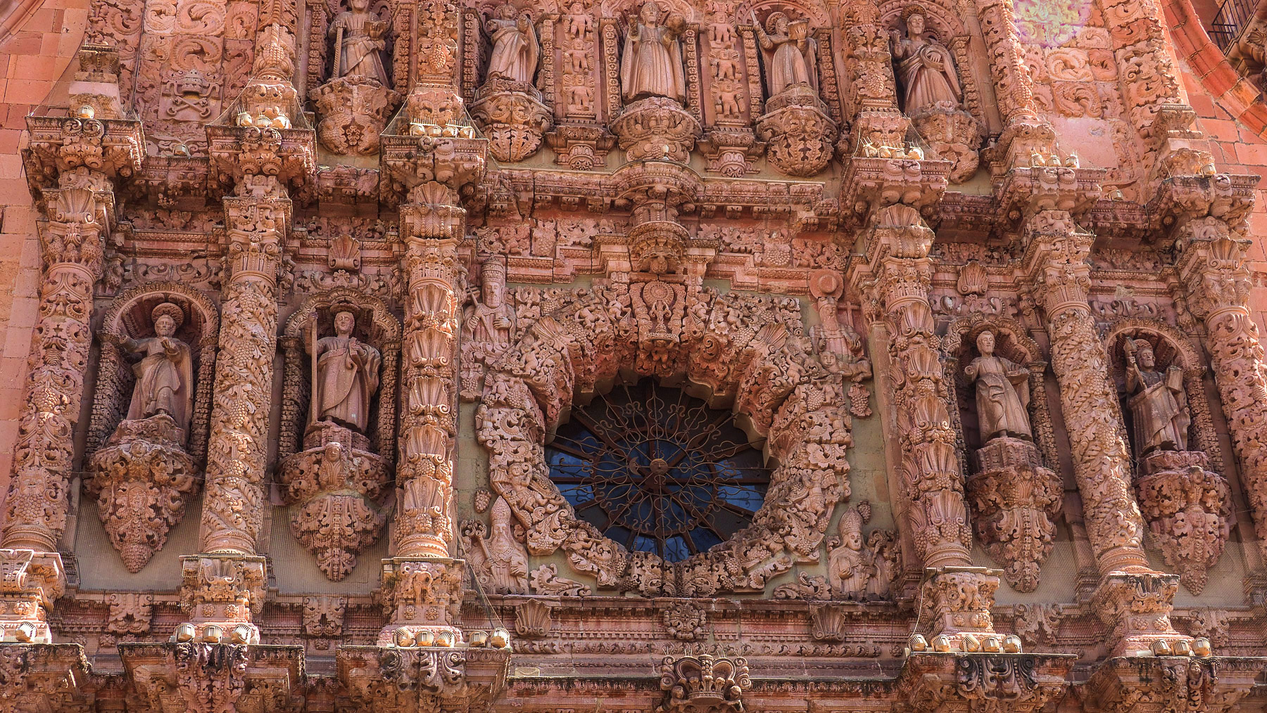 Detailreiche Hauptfassade in rosafarbenem Stein
